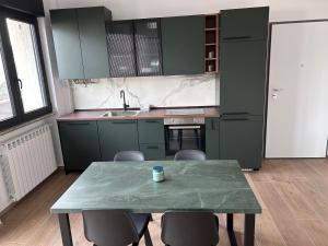 a kitchen with green cabinets and a table with chairs at NUVOLA Hosting in Segrate +13 photos