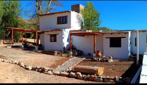a small white house with a yard with a yard at Cabañas Paqa Paqa in Maimará