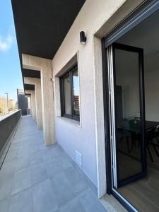 a balcony with a glass door and a table at NUVOLA Hosting in Segrate