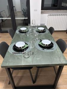 a green table with plates and glasses on it at NUVOLA Hosting in Segrate