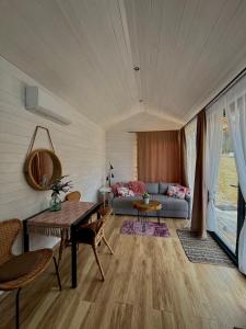 a living room with a couch and a table at Domek w górach Tiny House Forest Jacuzzi/widoki in Lipnica Wielka