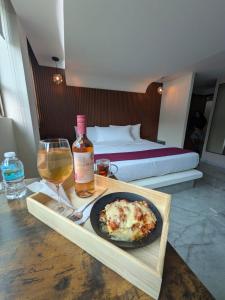 a table with a plate of food and a bottle of wine at Hotel Olimpica Boutique in Mexico City