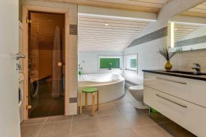 a bathroom with a tub and a toilet and a sink at BV406-Blavand-Tvaervaenget-2 in Blåvand +32 photos