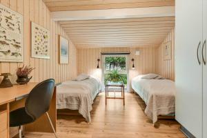 a bedroom with two beds and a desk and a table at BV406-Blavand-Tvaervaenget-2 in Blåvand