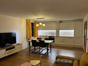 a living room with a table and a kitchen at Rumena hiša in Trnovo