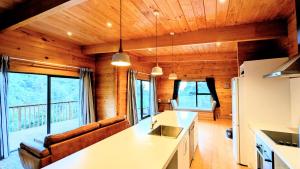 a kitchen and living room in a log cabin at Absolute Tranquility - surrounded by native bush in Kaiuma