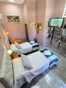 a room with three beds and a flat screen tv at Complejo Varge Norte in Alta Gracia