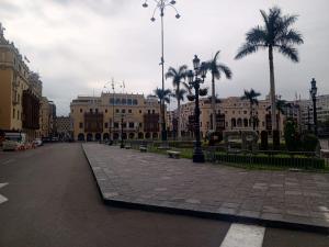 an empty city street with palm trees and buildings at Lima Centro Guest House Barrios in Lima