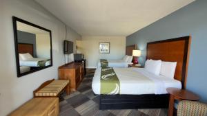 a hotel room with two beds and a mirror at Regency Inn in Chickasha