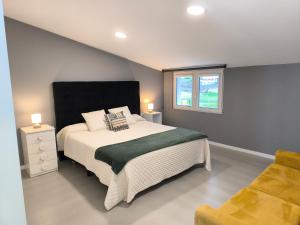 a bedroom with a large bed and a window at Atico Deluxe en Vimianzo in Toja
