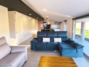 a living room with a blue couch and a table at Atico Deluxe en Vimianzo in Toja