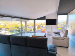 a living room with a couch and a tv at Atico Deluxe en Vimianzo in Toja