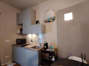 a small kitchen with a sink and a microwave at RiDi Home 466- Suite in centro a 5 minuti dal mare in Porto SantʼElpidio +18 photos