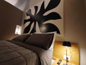 a bedroom with a bed with a black painting on the wall at RiDi Home 466- Suite in centro a 5 minuti dal mare in Porto SantʼElpidio
