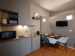 a kitchen with a small table and white chairs at RiDi Home 466- Suite in centro a 5 minuti dal mare in Porto SantʼElpidio