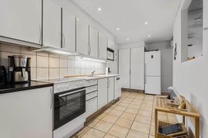 a kitchen with white cabinets and white appliances at BV230-Blavand-Vesterhavsparken-35 in Blåvand +10 photos