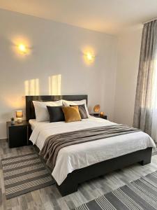a bedroom with a large bed with pillows at Serenity Apartments and Studios in Eforie Nord