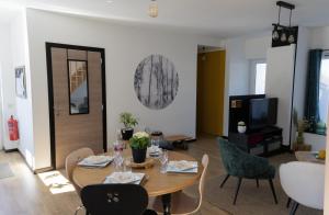 a living room with a wooden table and chairs at Au Coin du Bois in Manhay