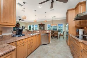 a large kitchen with wooden cabinets and a dining room at Villa Hibiscus-Waterfront-Free Heated Pool-Dock-Bikes-Other Amenities in Punta Gorda