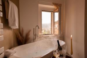 a bath tub in a bathroom with a window at Tosco Suite "Ecclesia" in Sasso dʼOmbrone