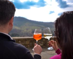 a man and a woman holding glasses of wine at Tosco Suite "Ecclesia" in Sasso dʼOmbrone