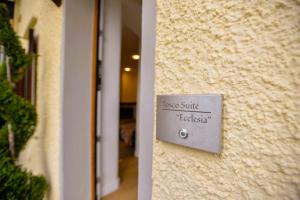 a sign on the side of a building at Tosco Suite "Ecclesia" in Sasso dʼOmbrone +11 photos