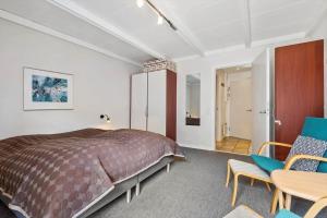 a bedroom with a bed and two chairs and a table at BV255-Blavand-Vesterhavsparken-39 in Blåvand