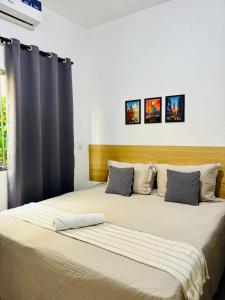a large bed in a room with two pillows at VOER - BR Flat Hospedaria in Sete Lagoas