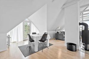 a white dining room with a table and chairs at BV326-Blavand-Blavandvej-4-2 in Blåvand