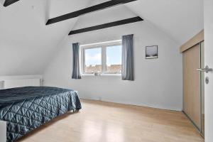 a bedroom with a bed and a window at BV326-Blavand-Blavandvej-4-2 in Blåvand