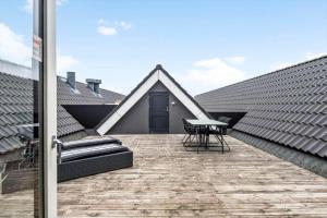 a patio with a table and chairs on a roof at BV326-Blavand-Blavandvej-4-2 in Blåvand