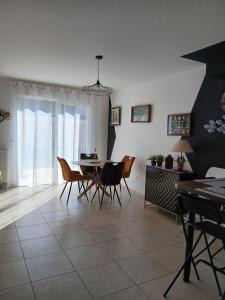 a dining room with a table and chairs at Bagatelle in Courseulles-sur-Mer