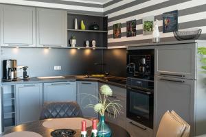 a kitchen with white cabinets and a table at Apartment MeerZeit in Büsum