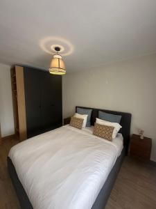 a large white bed in a room with a light at Appartement ALFONSO in Salou