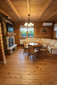 a living room with a couch and a table and a fireplace at Cottage Smerekovyi in Skole
