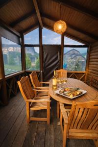 a wooden table with a plate of pizza on a balcony at Cottage Smerekovyi in Skole