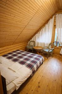 a bedroom with a bed and chairs in a room at Cottage Smerekovyi in Skole +19 photos