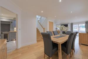 a kitchen and dining room with a wooden table and chairs at Connel House - Luxury self-catering 4-bedroom home in Connel