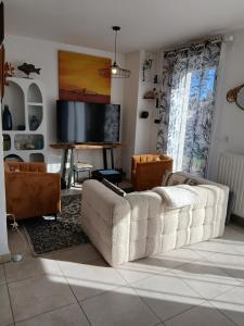 a living room with a couch and a flat screen tv at Bagatelle in Courseulles-sur-Mer