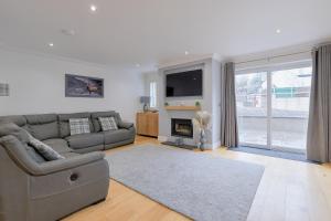 a living room with a couch and a fireplace at Connel House - Luxury self-catering 4-bedroom home in Connel