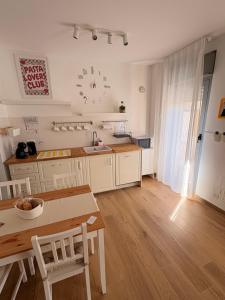 a kitchen with white cabinets and a table and a dining room at Solaria House in Montesilvano