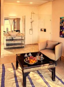 a living room with a table with a bowl of fruit on it at Bab Sma in Oumnas