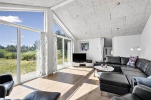 a living room with a couch and a large window at BV155-Blavand-Gronnevaenget-1-D in Blåvand