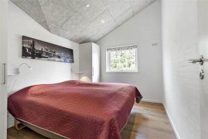 a bedroom with a bed with a red blanket at BV155-Blavand-Gronnevaenget-1-D in Blåvand