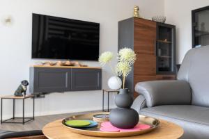 a living room with a vase with flowers on a table at Apartment MeerZeit in Büsum