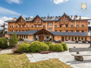 a large building with a bench in front of it at Gaarten Hotel Benessere Spa by Kleos Group Collection in Gallio