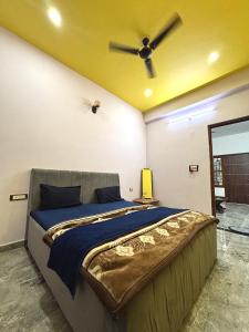a bedroom with a bed with a ceiling fan at Vrinda vas Homestay in Mathura