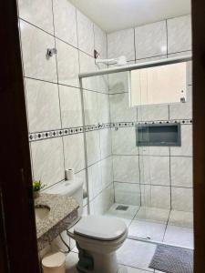 a white bathroom with a toilet and a sink at VOER - BR Flat Hospedaria in Sete Lagoas +64 photos