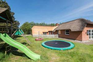 a backyard with a playground with a slide and a trampoline at BV319-Blavand-Savmollen-14 in Blåvand