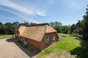 a small house with a straw roof on a yard at BV319-Blavand-Savmollen-14 in Blåvand